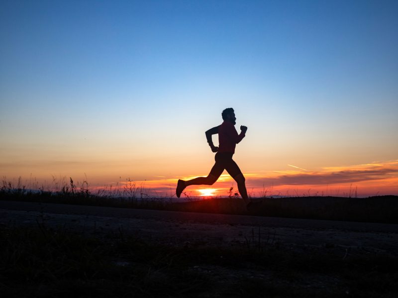 active man silhouette running at sunset