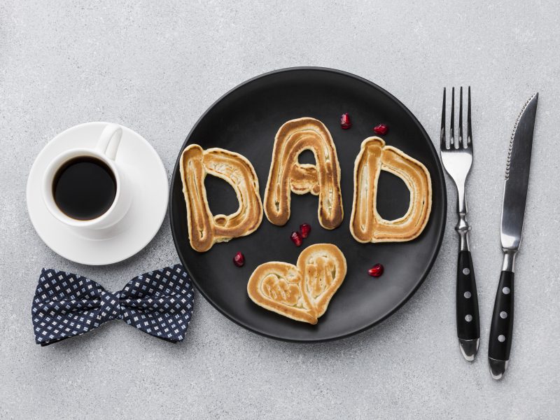 'Dad' on a plate with a coffee and bow tie one side and knife and fork the other