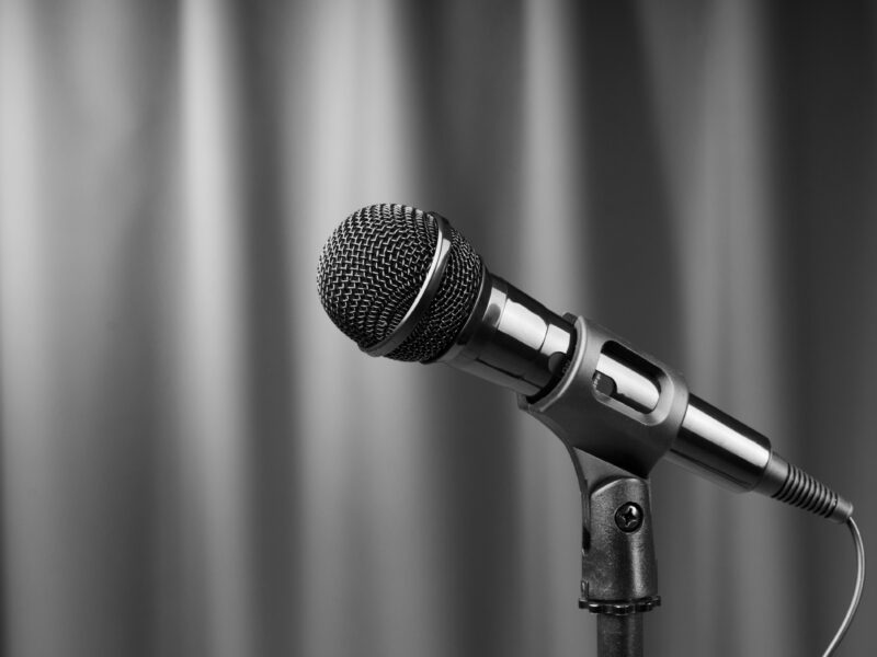 Image of a microphone with a grey curtain background