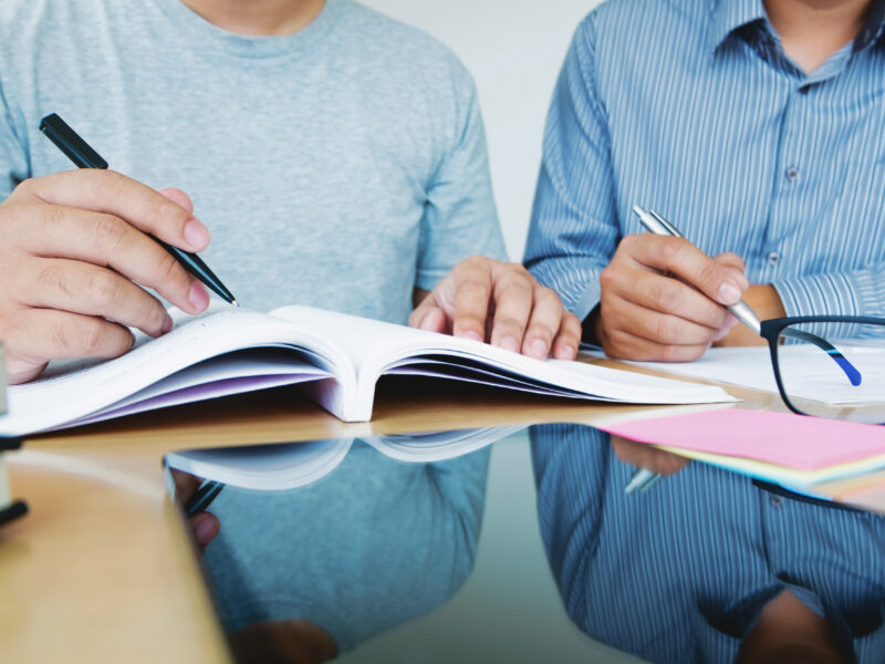 two students doing homework while sitting at a table