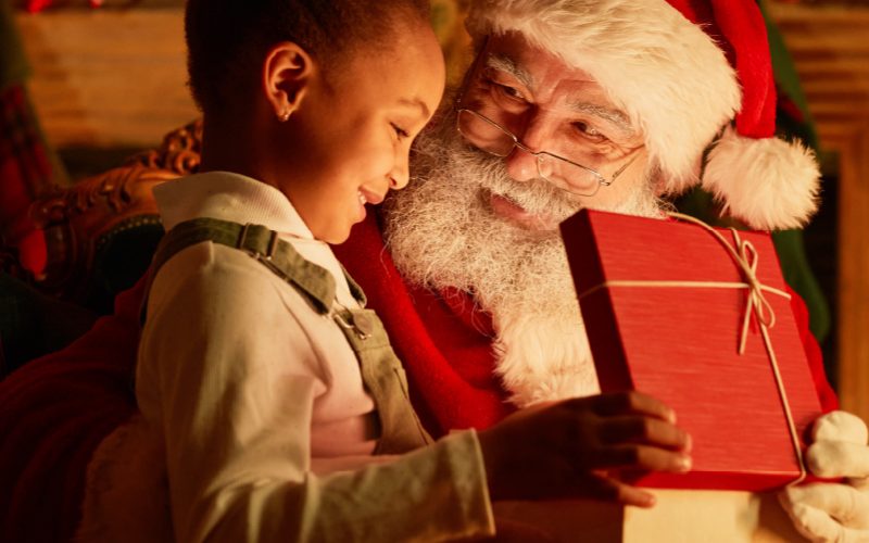 Close up of Santa giving a child a present